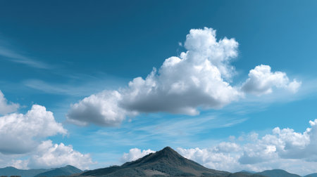 A tranquil landscape showcasing a lush green hill beneath a bright blue sky filled with dramatic clouds. This serene scene captures the beauty of nature.の素材