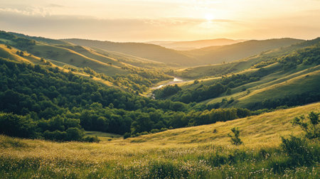 Rolling hills valley, gently sloping towards a river in the distance, surrounded by greeneryの素材