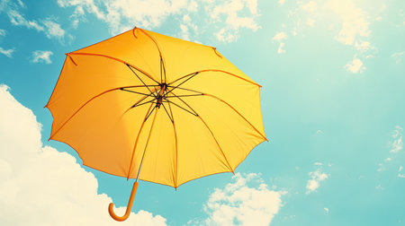 A cheerful yellow umbrella opened up on a bright sunny day, providing shade from the summer heatの素材