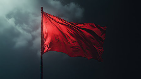 A red flag waving in the wind, symbolizing power, revolution, or alertness, depending on the contextの素材