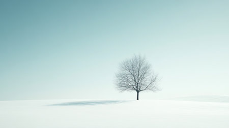 A tranquil winter landscape featuring a solitary tree against a soft, snowy background. This serene scene captures the essence of solitude and peace in nature.の素材