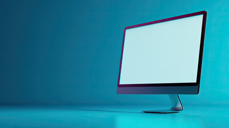 A sleek modern desktop computer with a blank screen set against a vibrant blue background, ideal for showcasing technology, innovation, and workspace themes.の素材