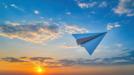 A paper plane glides through a vibrant sky at sunrise, symbolizing freedom and creativity. Perfect for concepts of travel, adventure, and imagination.の素材