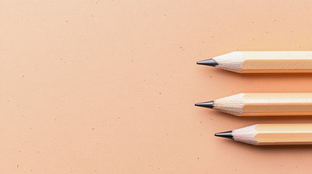 A serene arrangement of sharpened pencils on a smooth, orange background. Ideal for art, stationery, or creative design projects.の素材