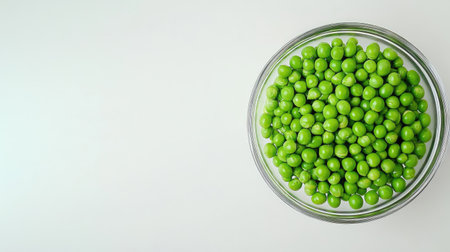A vibrant glass bowl filled with fresh green peas on a clean white background, showcasing the natural beauty of healthy food and fresh produce.の素材