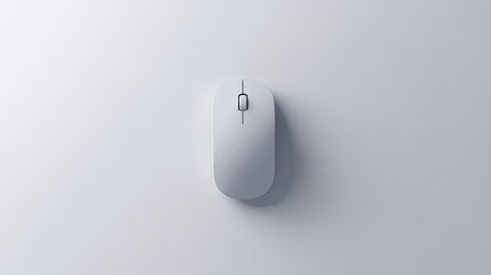 A sleek white computer mouse positioned on a smooth grey surface, embodying minimalistic design and modern technology for an elegant workspace atmosphere.の素材