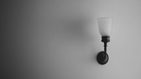 A stylish wall sconce casts a soft glow against a neutral backdrop, enhancing the ambiance of any space with its elegant design and modern appeal.の素材