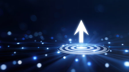 A striking image of a white arrow emerging from a circular target radiating bright blue light. Perfect for themes related to growth, progress, and achievement.の素材