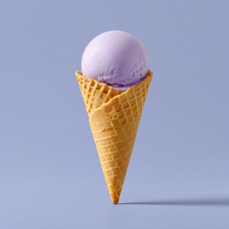 A beautifully styled image featuring a single scoop of purple ice cream in a classic cone. This vibrant dessert is perfect for tempting your audience on social media or marketing materials.の素材