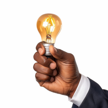 A close-up shot featuring a hand holding a vintage light bulb, illuminating warm light. This image symbolizes creativity, innovation, and bright ideas in a conceptual manner.の素材