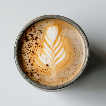 A beautifully crafted latte shows intricate leaf art atop the creamy surface, perfect for coffee lovers and food enthusiasts, offering a warm, inviting experience.の素材