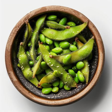 A vibrant arrangement of fresh edamame pods and bright green beans in a rustic clay bowl, showcasing healthy eating. Perfect for culinary and nutrition themes.の素材