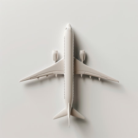 A top view of a sleek white airplane model placed on a light background, ideal for themes related to travel, transportation, and aviation design.の素材