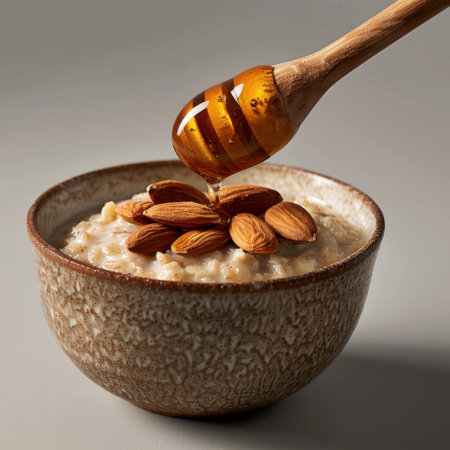A rich bowl of creamy oatmeal topped with almonds and a golden honey drizzle, ideal for a nutritious breakfast or snack.の素材
