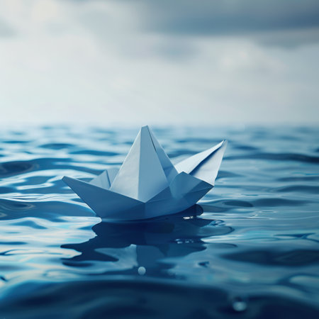 A delicate paper boat drifts gently on the surface of calm water, reflecting the clouds and sky above, evoking feelings of peace and adventure in nature.の素材