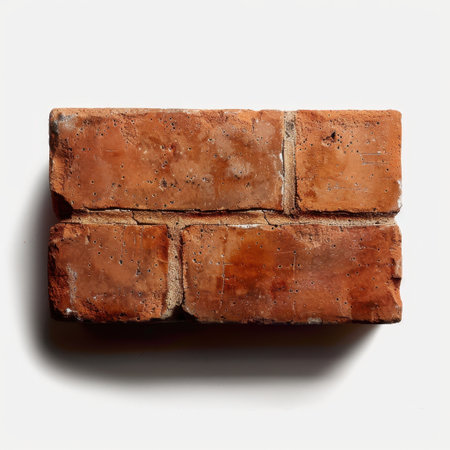 A detailed close-up view of an aged red brick showcasing its unique texture and color variations. Ideal for construction or design concepts.の素材