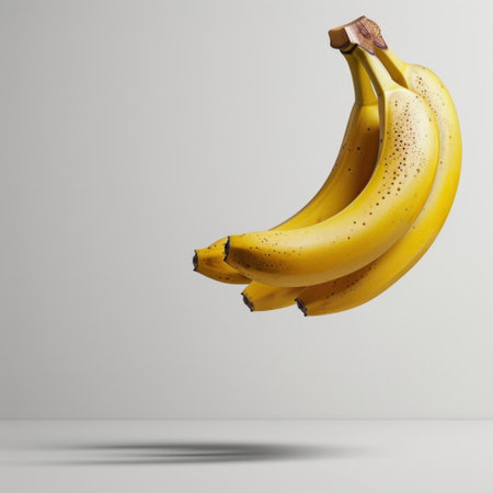 This image features fresh bananas with vibrant yellow skin, artistically positioned on a plain white background, emphasizing their freshness and natural appeal.の素材