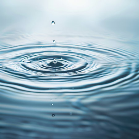 A mesmerizing droplet falls onto a tranquil water surface, creating delicate ripples and reflections. This image captures the serenity and elegance of nature in motion.の素材
