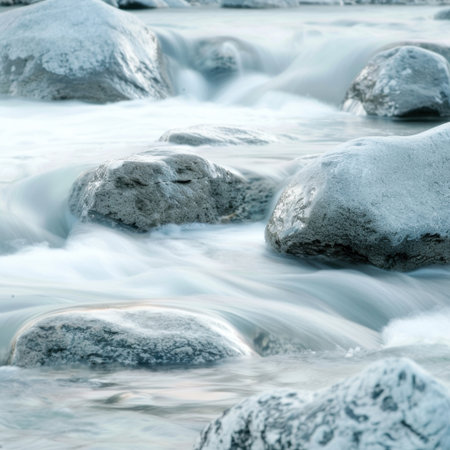 A beautiful scene of clear water flowing smoothly over rounded rocks in a serene stream. This picturesque view evokes feelings of calmness and tranquility in nature.の素材