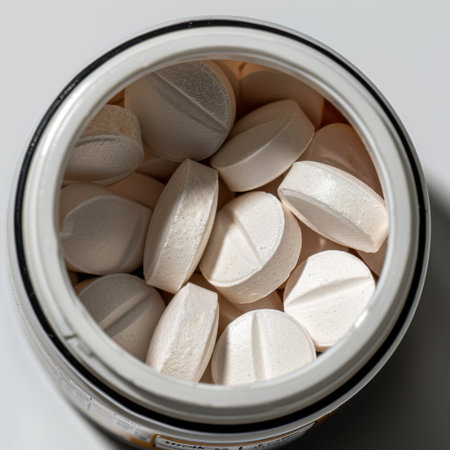 A clear close-up image of round white tablets inside a jar, ideal for illustrating health and wellness themes related to medication, supplements, or nutrition.の素材