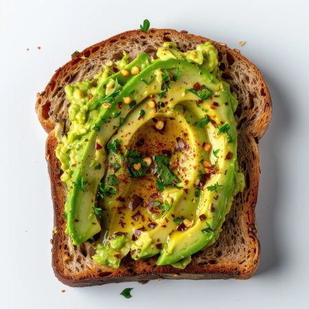 A beautifully arranged slice of toasted bread topped with creamy avocado spread, garnished with red pepper flakes and fresh parsley, perfect for health-conscious food lovers.の素材