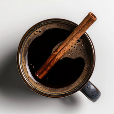 A close-up view of a warm cup of coffee featuring a cinnamon stick, enhancing the inviting aroma and comfort, ideal for cozy settings and morning rituals.の素材