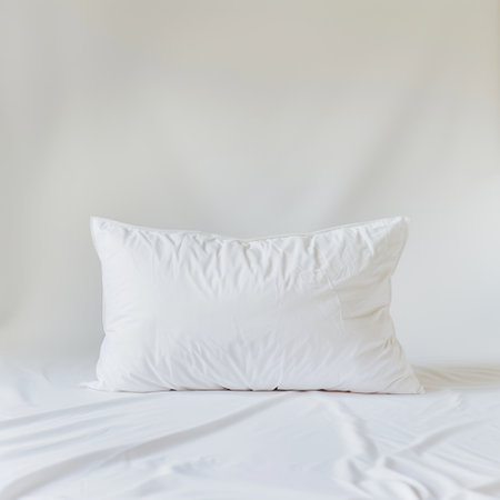 A soft white pillow rests elegantly on a smooth white bed sheet, capturing the essence of minimalism and comfort perfect for home decoration and relaxation.の素材