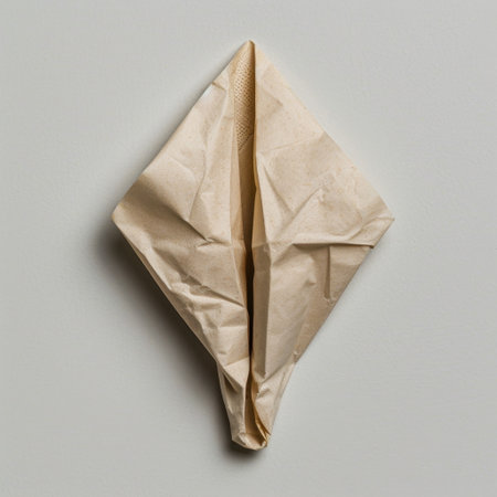 A crumpled brown paper sculpture shaped like a diamond, displayed against a smooth gray background, exemplifying modern minimalist art and creative design.の素材