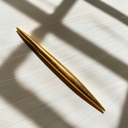 This image features a sleek gold pen resting on a textured white surface, illuminated by soft natural light, showcasing elegance and minimalism perfect for workspace inspiration.の素材