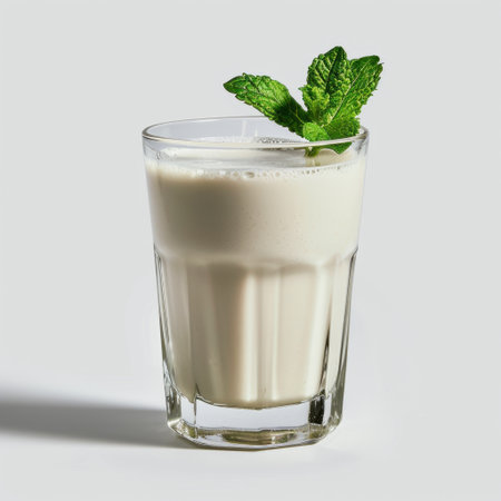 Enjoy a delectable and refreshing glass of creamy milk topped with a sprig of mint, perfect for culinary photography, recipes, and gastronomic delights.の素材