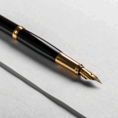Close-up of an elegant black fountain pen with gold accents, resting on smooth paper, highlighting its sophisticated design and impeccable craftsmanship for writing.の素材