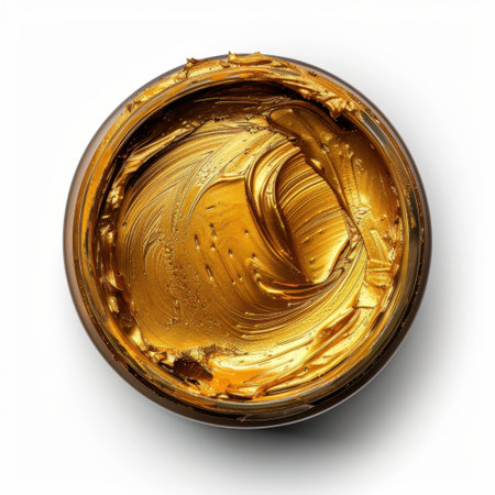 A close-up view of creamy golden ointment in a clear round container, showcasing its smooth texture and luxurious appearance, perfect for beauty and creative projects.の素材