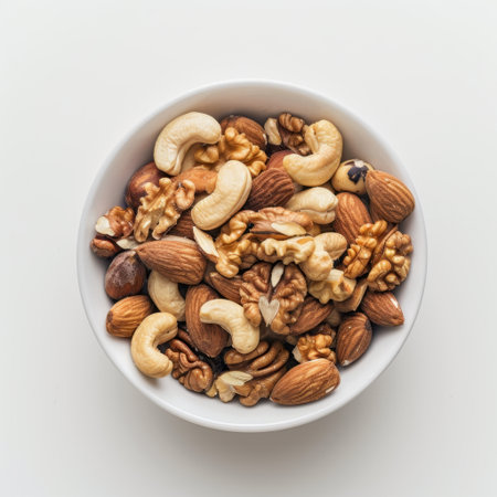 A vibrant assortment of nuts in a white bowl showcases a variety of flavors and textures. Ideal for healthy snacking and enriching diets with essential nutrients.の素材