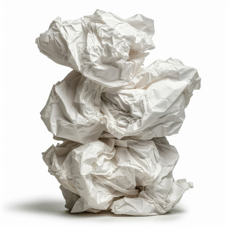 A stack of crumpled white paper sits against a plain backdrop, creating an interesting visual texture. Ideal for business presentations, artistic projects, or recycling themes.の素材