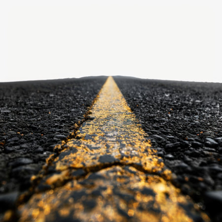 A striking image of an empty asphalt road with a vivid yellow line running down the center, extending towards a bright white sky, symbolizing freedom and adventure.の素材