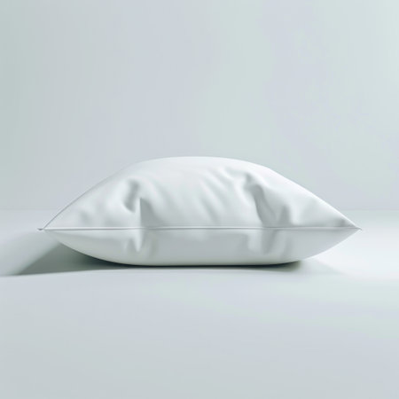 A serene and soft white pillow resting gently on a light and minimalistic surface, ideal for enhancing comfort and style in modern home interior settings.の素材