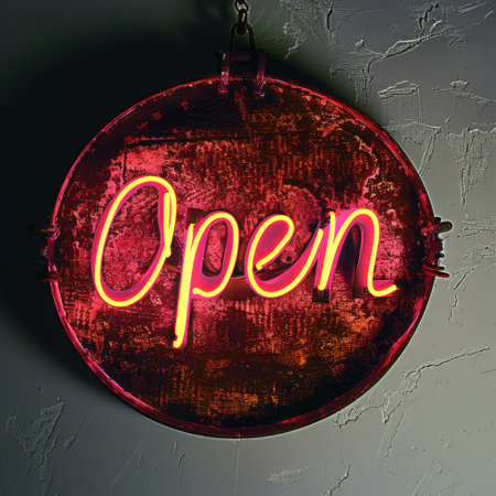 A striking neon sign displaying the word "Open" in vibrant pink and yellow hues. It captures attention against a rustic, industrial-style wall, creating a warm welcome.の素材