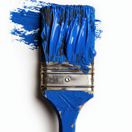 This image features a close-up of a paintbrush loaded with bright blue paint, showcasing the bristles and the fresh color against a neutral background, perfect for creative projects.の素材