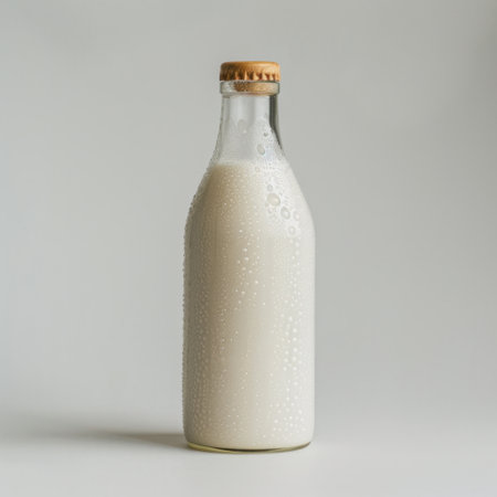A rustic glass bottle of fresh milk with a cork lid on a clean white background, ideal for promoting healthy lifestyles, gourmet cooking, and organic products.の素材