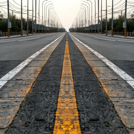 An expansive view of a tranquil road featuring distinct yellow lane markings, stretching into the distance under a clear sky, evoking a sense of adventure and freedom.の素材