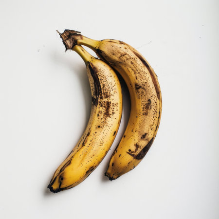 This image features two ripe bananas with distinct brown spots on a clean white background, perfect for illustrating healthy eating, freshness, and tropical themes.の素材