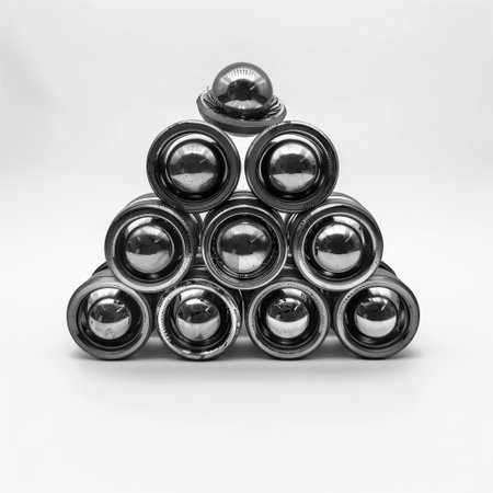 A visually appealing stack of shiny silver food cans is arranged in a pyramid formation on a clean white background, perfect for culinary-themed visuals and stock images.の素材