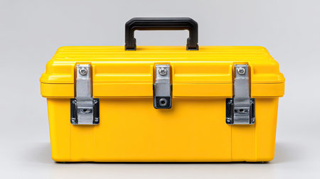 This bright yellow toolbox features a sturdy black handle and metallic latches, perfect for organizing tools and equipment for various projects at home or work.の素材