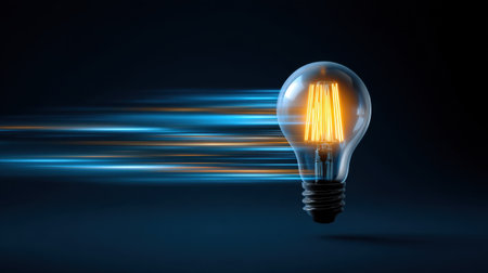 A vibrant image of a glowing light bulb with a classic filament, set against a dark backdrop, showcasing themes of innovation and speed through dynamic motion effects.の素材