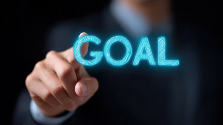 A determined businessman points at the word "goal," symbolizing a strong desire for achievement and ambition within a professional environment and motivational context.の素材