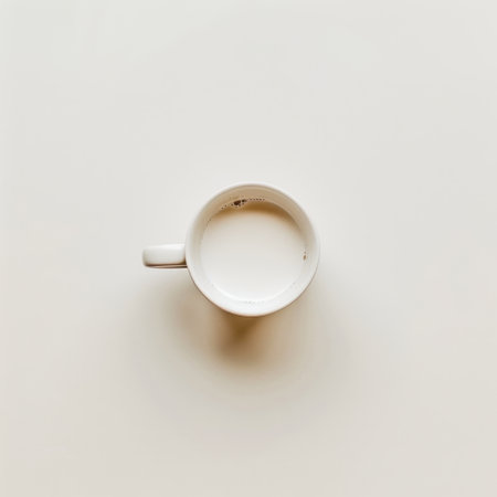 A minimalist coffee cup filled with milk rests on a soft beige background, capturing a serene moment perfect for cozy mornings and modern aesthetics.の素材