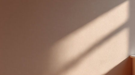 A serene composition featuring soft natural light casting delicate shadows on a plain wall, creating a calming atmosphere ideal for interior design inspiration.の素材