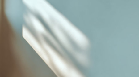 A serene image capturing soft light and gentle shadow cast on a smooth surface, creating an abstract feel with warm tones and subtle textures, ideal for artistic projects.の素材