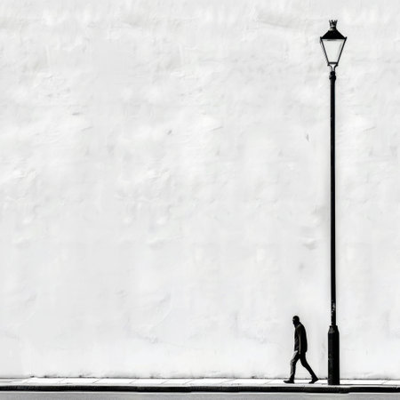 A lone figure walks past a street lamp against a stark white wall, capturing themes of solitude and minimalism in an urban setting that evokes contemplation.の素材