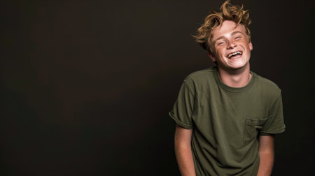 This image captures a joyful young man laughing against a dark background. His genuine smile and relaxed pose evoke feelings of happiness and carefree moments, making it ideal for various lifestyle themes.の素材